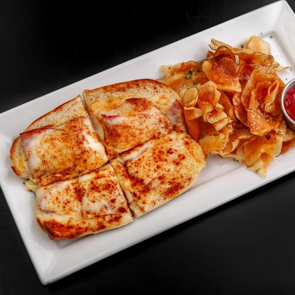 Four cheesy sandwiches with paprika, served with crispy chips and a side of ketchup.
