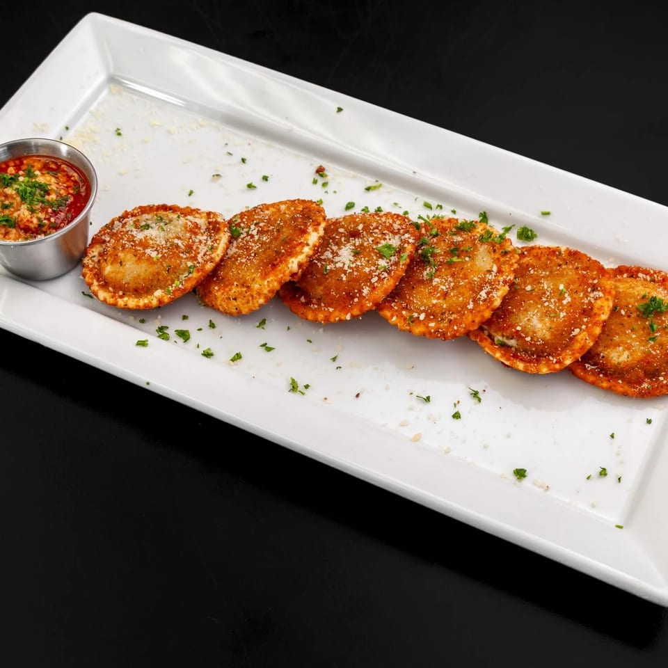 Fried ravioli with parmesan cheese and parsley, served with a side of marinara sauce.