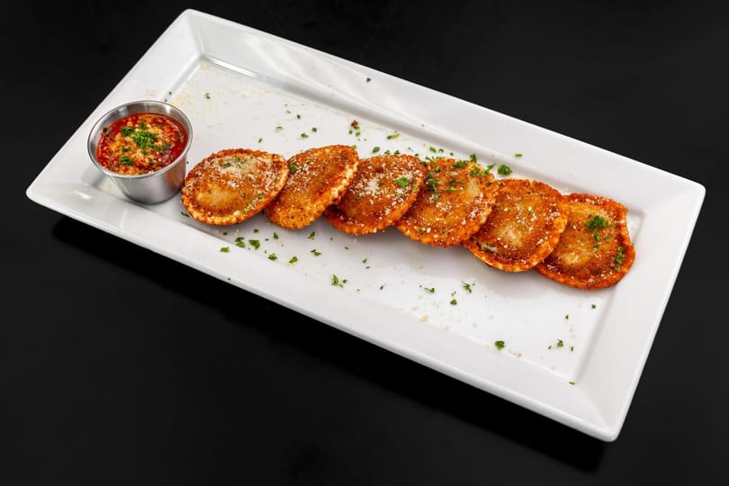 Fried ravioli with parmesan cheese and parsley, served with a side of marinara sauce.